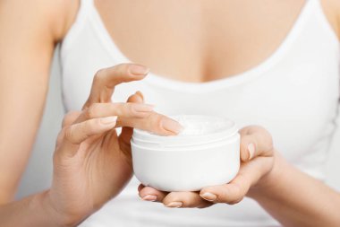 Krem tutarak ve nemlendirici el kremi uygulama kadın el closeup çekim. Güzel eller krema ile. El Cilt Bakımı. Bir kadının vücut losyonu kollarında kullanır. Güzellik ve vücut bakım kavramı 