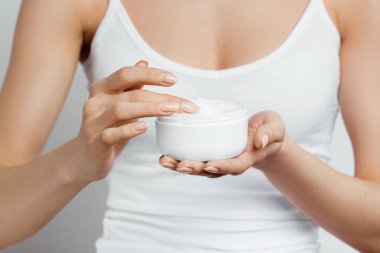 Krem tutarak ve nemlendirici el kremi uygulama kadın el closeup çekim. Güzel eller krema ile. El Cilt Bakımı. Bir kadının vücut losyonu kollarında kullanır. Güzellik ve vücut bakım kavramı 