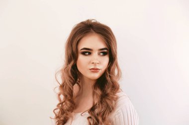 Uzun dalgalı saçlı güzel bir kız. Esmer, kıvırcık saçlı.