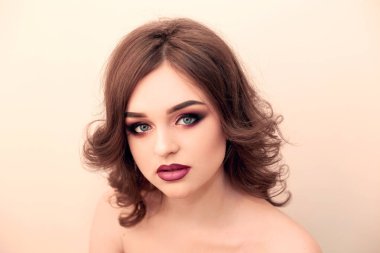 Uzun, parlak dalgalı saçlı esmer kız. Güzel model kıvırcık saç modeli ile. Kadın güzel elleri ile Fransız manikür 