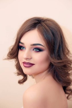 Uzun, parlak dalgalı saçlı esmer kız. Güzel model kıvırcık saç modeli ile. Kadın güzel elleri ile Fransız manikür 