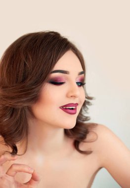 Kıvırcık saçlı, moda lüks makyaj güzel model kız. Güzel genç kadın temiz taze cilt ile kapatın. Cilt bakımı yüz. Kozmetik. Güzellik kadını yüz portre.