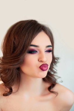 Kıvırcık saçlı, moda lüks makyaj güzel model kız. Güzel genç kadın temiz taze cilt ile kapatın. Cilt bakımı yüz. Kozmetik. Güzellik kadını yüz portre.