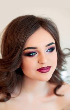 Kıvırcık saçlı, moda lüks makyaj güzel model kız. Güzel genç kadın temiz taze cilt ile kapatın. Cilt bakımı yüz. Kozmetik. Güzellik kadını yüz portre.