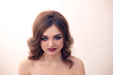 Kıvırcık saçlı, moda lüks makyaj güzel model kız. Güzel genç kadın temiz taze cilt ile kapatın. Cilt bakımı yüz. Kozmetik. Güzellik kadını yüz portre.