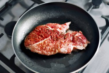 Dökme demir tavada rozbif, et sadece üst tarafı hala kırmızı kızgın yağ için eklendi