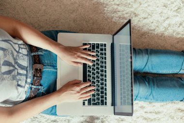Bir dizüstü bilgisayarda çalışan kadın. Web, arama bilgi tarama, evde çalışma alanı olan kadın katta, oturan bir dizüstü bilgisayar kullanarak. Bloglama kavramını. Modern teknolojiler. Üstten Görünüm.