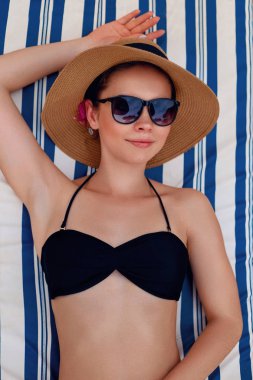 Sahil üzerinde güneşlenme rahat genç kadın