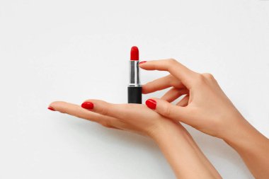Beyaz arka plan üzerinde izole bir kadın eli açık rujla. Kırmızı tırnak. Reklam. Metin arka planı için yer