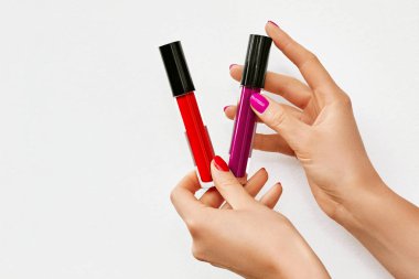 Eller ile dudak glosses izole üzerinde beyaz. Kırmızı ve pembe dudak glosses tutan kadın. Metin için yer