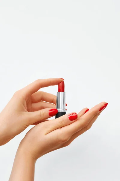 Woman\'s Hands with Red Nail Polish and Red Lipstick on a White Background