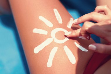 Tatlı kadın bacak güneş şeklinde. Güneş koruma güneş krem düzgün tabaklanmış bacaklarını. Güneş kremi. Cilt Bakımı. 