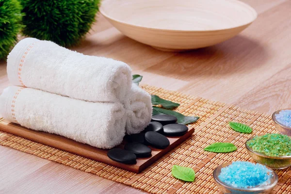 Beautiful spa and wellness setting composition on massage table in relax center on blackboard with copy space.Towel, Salt, Plumeria Flower, Bowl for spa therapy.Spa  products