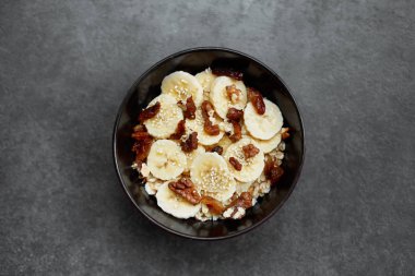 Muz, fındık, kuru üzüm, susam ile yulaf ezmesi lapası ile sağlıklı kahvaltı konsepti Üst görünümü. Süper yemek. Granola ve musli yapılan gıda.