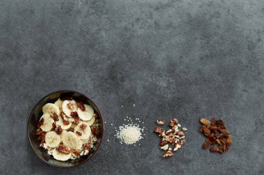 Muz, fındık, kuru üzüm, susam ile yulaf ezmesi lapası ile sağlıklı kahvaltı konsepti Üst görünümü. Süper yemek. Granola ve musli yapılan gıda.