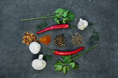  Siyah arka plan üzerinde çeşitli otlar ve baharatlar. Biber, Tuz, Kırmızı biber, sarımsak, zerdeçal, bezelye. Üstte görüntü.
