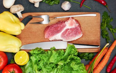 Taze sığır biftek, tahta kaşık, Taze Sebze Çeşitleri, aromatik otlar, baharat ve sebze pişirmek için , siyah arka plan, üst görünümü. Et