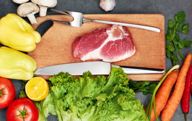 Taze sığır biftek, tahta kaşık, Taze Sebze Çeşitleri, aromatik otlar, baharat ve sebze pişirmek için , siyah arka plan, üst görünümü. Et