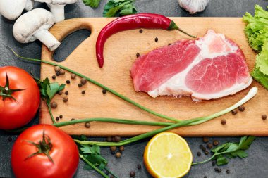 Taze sığır biftek, tahta kaşık, Taze Sebze Çeşitleri, aromatik otlar, baharat ve sebze pişirmek için , siyah arka plan, üst görünümü. Et