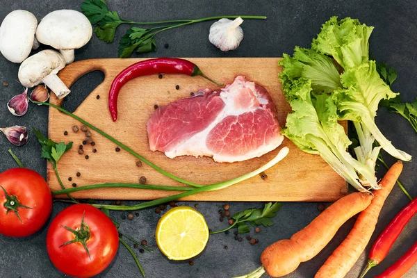 Taze sığır biftek, tahta kaşık, Taze Sebze Çeşitleri, aromatik otlar, baharat ve sebze pişirmek için , siyah arka plan, üst görünümü. Et