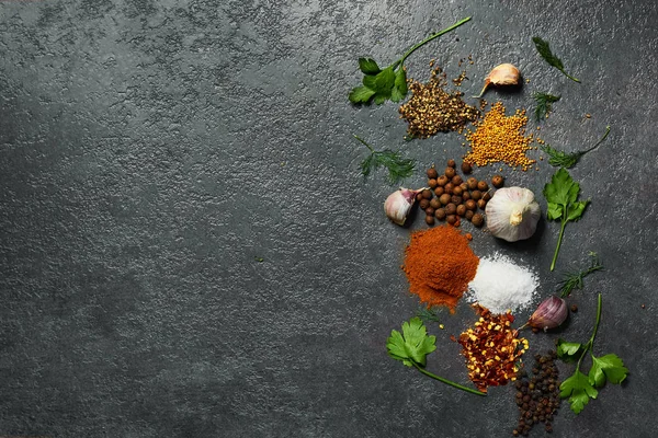  Siyah arka plan üzerinde çeşitli otlar ve baharatlar. Tuz, sarımsak, zerdeçal, bezelye. Kopyalama alanı ile üstte görünüm.