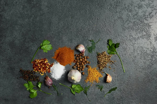  Siyah arka plan üzerinde çeşitli otlar ve baharatlar. Tuz, sarımsak, zerdeçal, bezelye. Kopyalama alanı ile üstte görünüm.