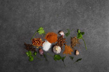  Siyah arka plan üzerinde çeşitli otlar ve baharatlar. Biber, Tuz, Kırmızı biber, sarımsak, zerdeçal, bezelye. En iyi görünüm kopyalama alanı.