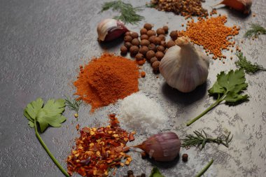  Siyah arka plan üzerinde çeşitli otlar ve baharatlar. Biber, Tuz, Kırmızı biber, sarımsak, zerdeçal, bezelye. En iyi görünüm kopyalama alanı.