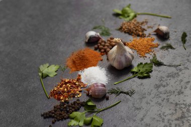 Baharat seçimi, siyah taş masada otlarl. Yemek pişirmek için malzemeler. Yemek geçmişi. Kopyalama alanı ile üstte görünüm.
