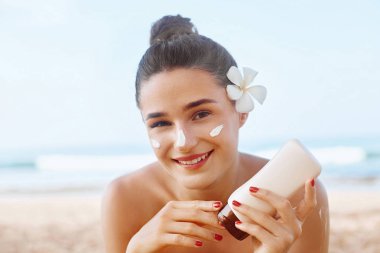 Güneş kremi ve güneş kremi. Kadın güzel yaz günü gülümseyerek burun güneş kremi koyarak. Skincare. Güneş kremi uygulayan kız. Güneş