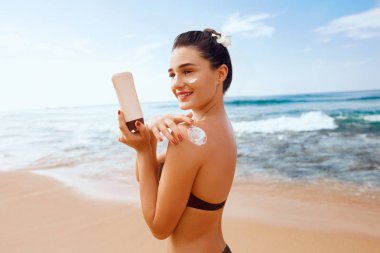 Bikini Güzel Kadın Tabaklanmış Omuz Güneş Kremi Uygulayarak. Güneş koruma. Cilt ve Vücut Bakımı. Cilt için Güneş Kremi Kullanarak Kız. Kadın Holding Suntan Losyonu ve Nemlendirici Güneş Kremi Portresi.
