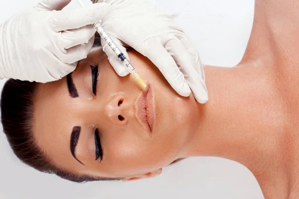 Woman Getting Beauty Injection For Lips.  beauty. Plastic surgery, beauty, Spa concept. Facial Rejuvenation. Lip augmentation. Portrait female  receiving treatment.Closeup hand in glove with syringe making injection