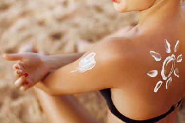 Güneş koruyucu krem uygulayarak kadının omuz bronzlaşmış. Cilt Bakımı. Vücut güneş koruma suncream. Bikini şapka kadın sırt üstü nemlendirici güneş koruyucu losyon uygulamak.