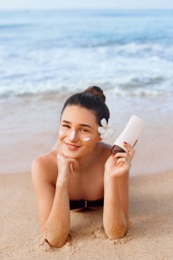 Bikini'de Güzellik Kadın Elinde Güneş Kremi Şişeleri Tutuyor. Skincare. Güzel Bir Kadın Güneş Kremi Uygulayarak. Güneş koruması kullanarak. Kız cilt üzerinde nemlendirici losyon yayma. Güneş