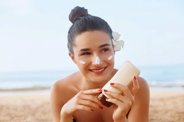 Suncream. Suntan Lotion Beautiful Woman Applying on beautifu on Face. Sunscreen Solar Cream. Skin care. Sun protection.The Girl Uses  Moisturizer Sunblock