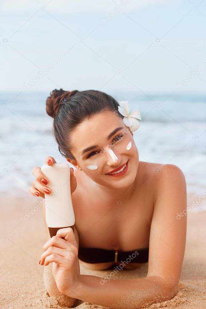Beauty Woman in Bikini Holding Bottles of Sunscreen in Her Hands. Skincare. A Beautiful Female Applying Sun Cream. Using Sun protection. Girl  smear moisturizing lotion on skin. Suntan