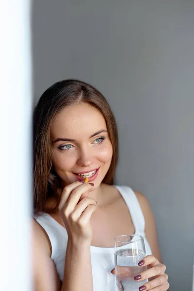 Feliz Mujer Sonriente Positiva Comiendo Píldora Sosteniendo Vaso Agua Mano — Foto de Stock