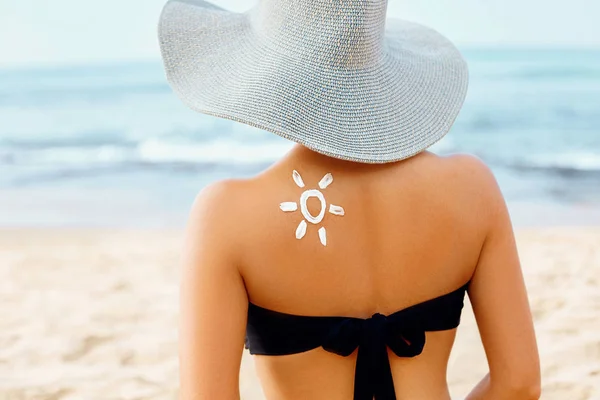 자외선 우먼은 선크림을 바뜨입니다 태양의 형태로 해변에 로션을 어깨에 그려진 — 스톡 사진