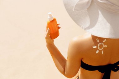 Bikini Elinde Güneş Kremi Şişeleri Tutan Seksi Genç Kadın. Skincare. Güzel Bir Kadın Güneş Kremi Uygulayarak. Güneş koruması kullanarak. Kız cilt üzerinde nemlendirici losyon yayma. Güneş