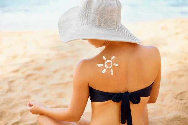 Beauty Woman with sun shaped sunscreen on her back. Skin care. Sun protection. Sun cream