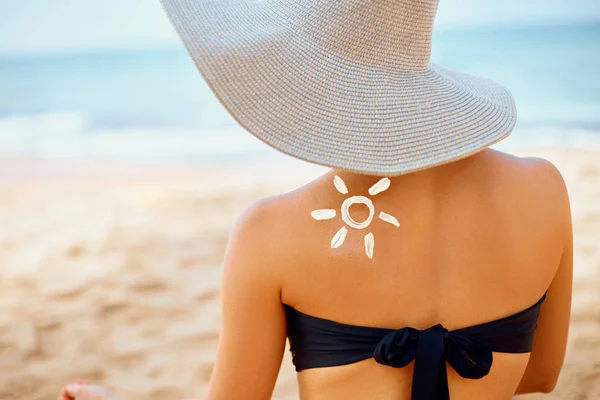 Sun cream on tanned shoulder. Sun protection. Beautiful woman in bikini applying  Solar Cream.  Skin and body care. Portrait of female holding suntan lotion and moisturizing sunblock.