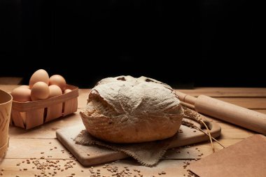 Taze pişmiş ekmek. Ahşap arka planda somun ekmek, yemek yakın çekim. Mayada ekmek. Mayasız ekmek.