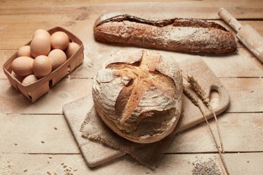 Taze pişmiş ekmek. Ahşap arka planda somun ekmek, yemek yakın çekim. Mayada ekmek. Mayasız ekmek.