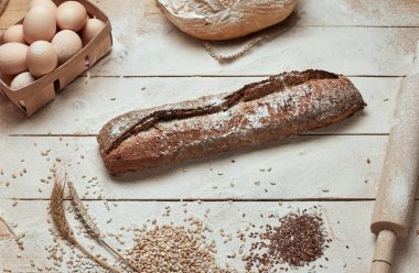 Ekmek fırın altın rustik kabuklu somun ve ahşap arka plan üzerinde. Yukarıdan yakalanan natürmort (üstte, düz yatıyordu).