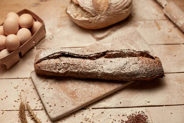 Ekmek fırın altın rustik kabuklu somun ve ahşap arka plan üzerinde. Yukarıdan yakalanan natürmort (üstte, düz yatıyordu).