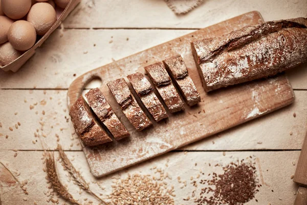 Taze pişmiş ekmek. Koyu ruktik ahşap arka plan closeup üzerinde dilimlenmiş kepekli ekmek üst görünümü. Mayada ekmek. Mayasız ekmek.