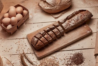 Taze pişmiş ekmek. Koyu ruktik ahşap arka plan closeup üzerinde dilimlenmiş kepekli ekmek üst görünümü. Mayada ekmek. Mayasız ekmek.