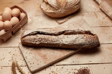 Ekmek fırın altın rustik kabuklu somun ve ahşap arka plan üzerinde. Yukarıdan yakalanan natürmort (üstte, düz yatıyordu).