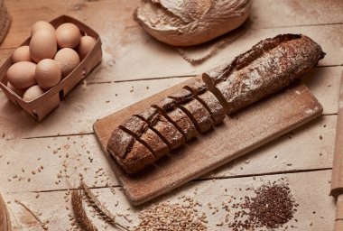 Taze pişmiş ekmek. Koyu ruktik ahşap arka plan closeup üzerinde dilimlenmiş kepekli ekmek üst görünümü. Mayada ekmek. Mayasız ekmek.