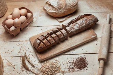 Taze pişmiş ekmek. Koyu ruktik ahşap arka plan closeup üzerinde dilimlenmiş kepekli ekmek üst görünümü. Mayada ekmek. Mayasız ekmek.